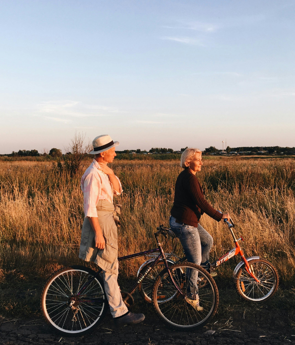 Older couple enjoying a bike ride at sunset