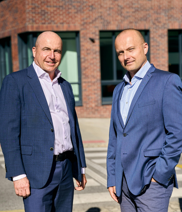 Two professionals standing confidently outside a modern building